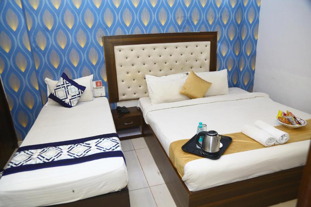 two beds in a hotel room with at Hotel MN Grand Shamshabad Airport Zone Hyderabad in Shamshabad