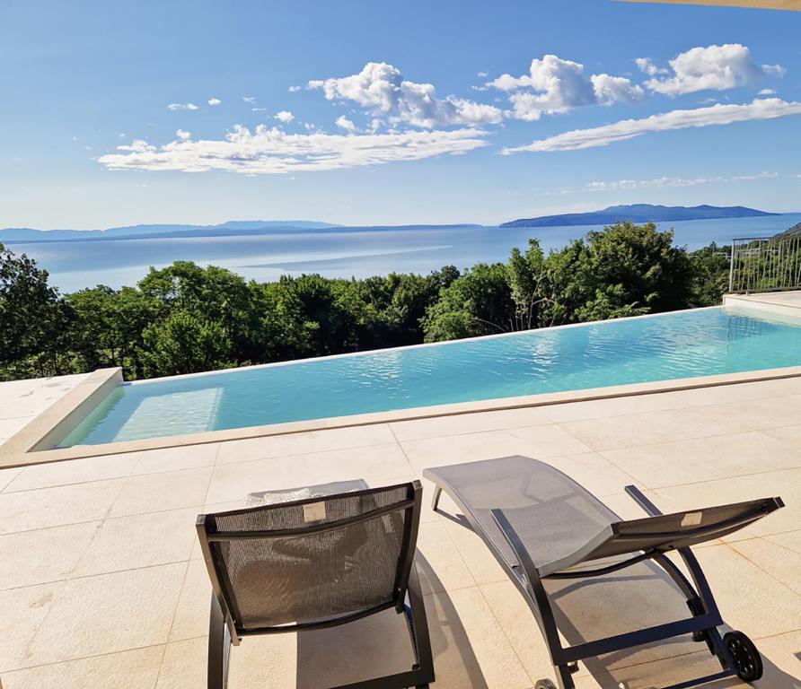 eine Terrasse mit einem Stuhl und einem Pool in der Unterkunft Villa Maritima-Meerblick-Infinity Pool-Luxus-Relax in Poljane