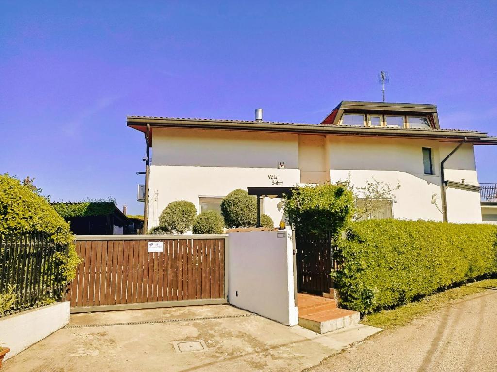 ein weißes Haus mit einem Tor und einem Zaun in der Unterkunft Villa Sabry in Turriaco