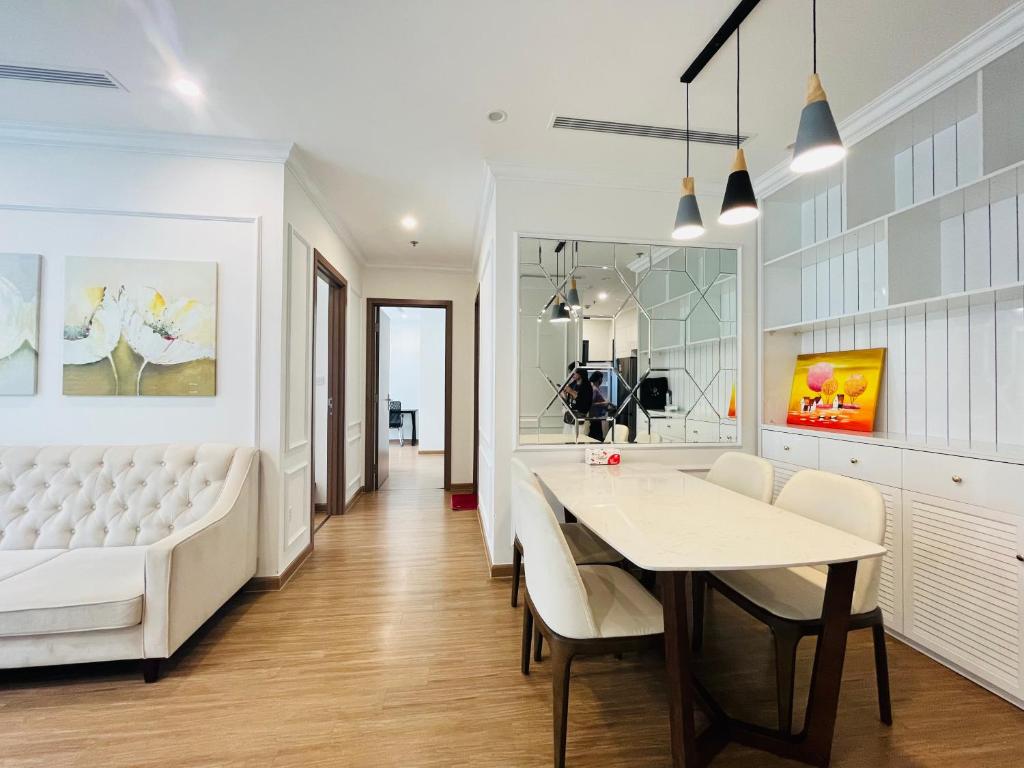 comedor con sofá blanco y mesa en Nanahousing-3 Bedroom Apartment Vinhomes Skylake, en Hanói