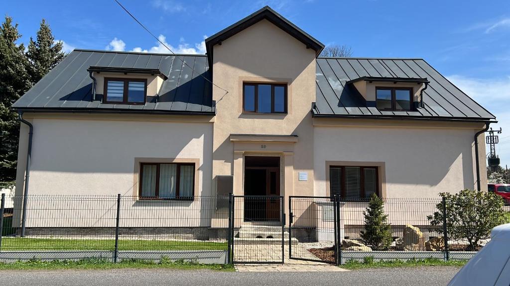 uma casa branca com um telhado preto em apartmán Crystalindo em Smržovka