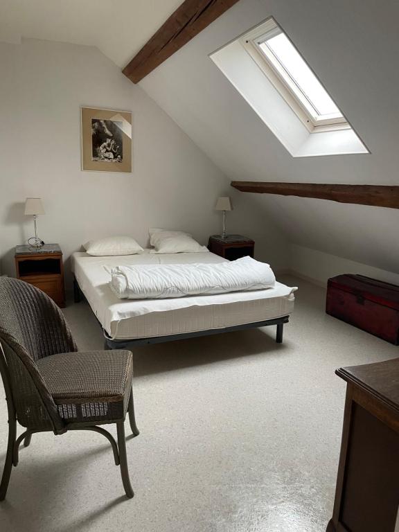 a bedroom with a bed and a skylight at Les 3 Gamins in Boussac