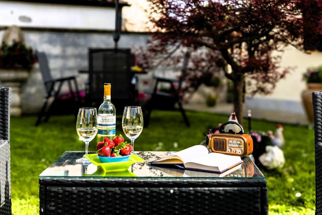 una mesa con dos copas y una botella de vino en Hostly-Garden House Metato-Apartment with Garden, 15min from sea, en Fiocina