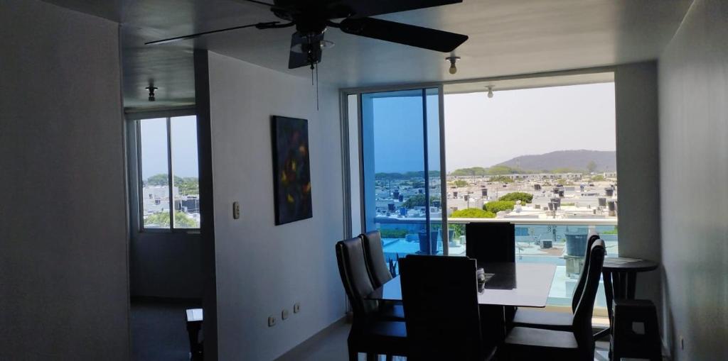 ein Esszimmer mit einem Tisch und Stühlen sowie einem großen Fenster in der Unterkunft Apartamento mirador de la sierra 2 in Valledupar