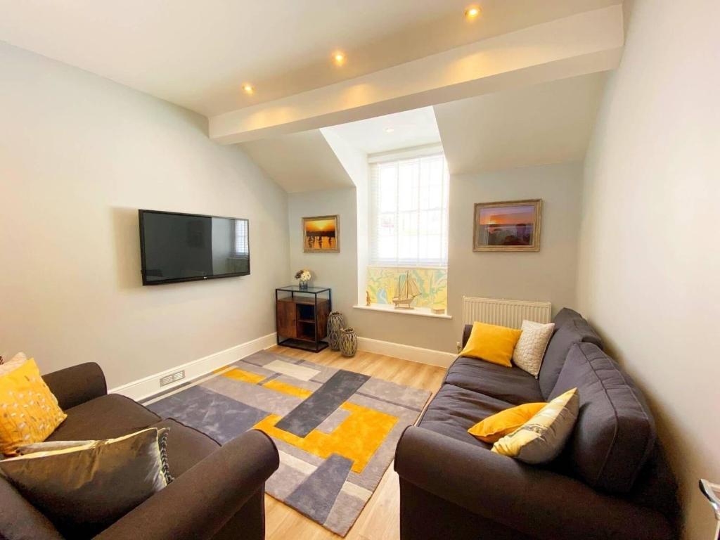 un soggiorno con divano e TV a schermo piatto di Ferienwohnung für 4 Personen ca 80 qm in Torquay, England Südküste von England a Torquay