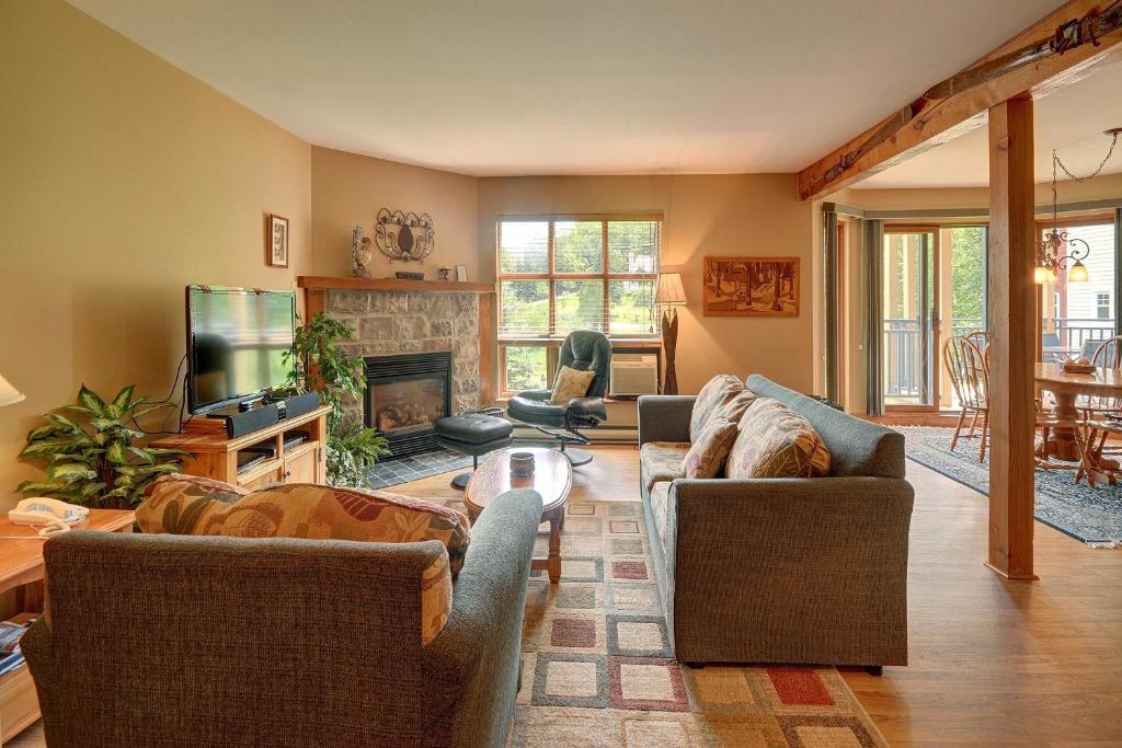 a living room with two couches and a fireplace at Jardin du Village by Chez Tremblant in Mont-Tremblant