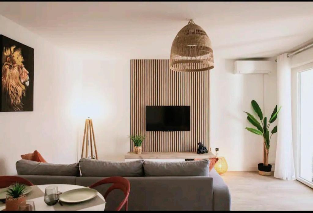 a living room with a couch and a tv at Le Candle - Parking & Balcon - Muret - Toulouse in Muret