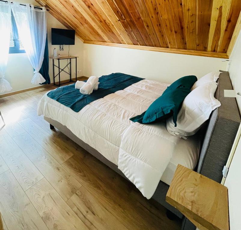 ein Schlafzimmer mit einem großen Bett und einer Holzdecke in der Unterkunft Au sommet des Salazes in Salazie