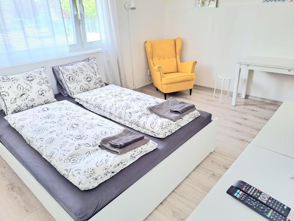 a white bed with two pillows and a chair at Garsónka v Bratislave in Bratislava