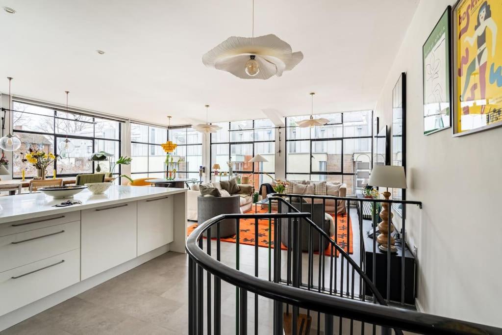 a kitchen with white cabinets and a spiral staircase at Unique Flat with Pool in Trendy Peckham Area in London
