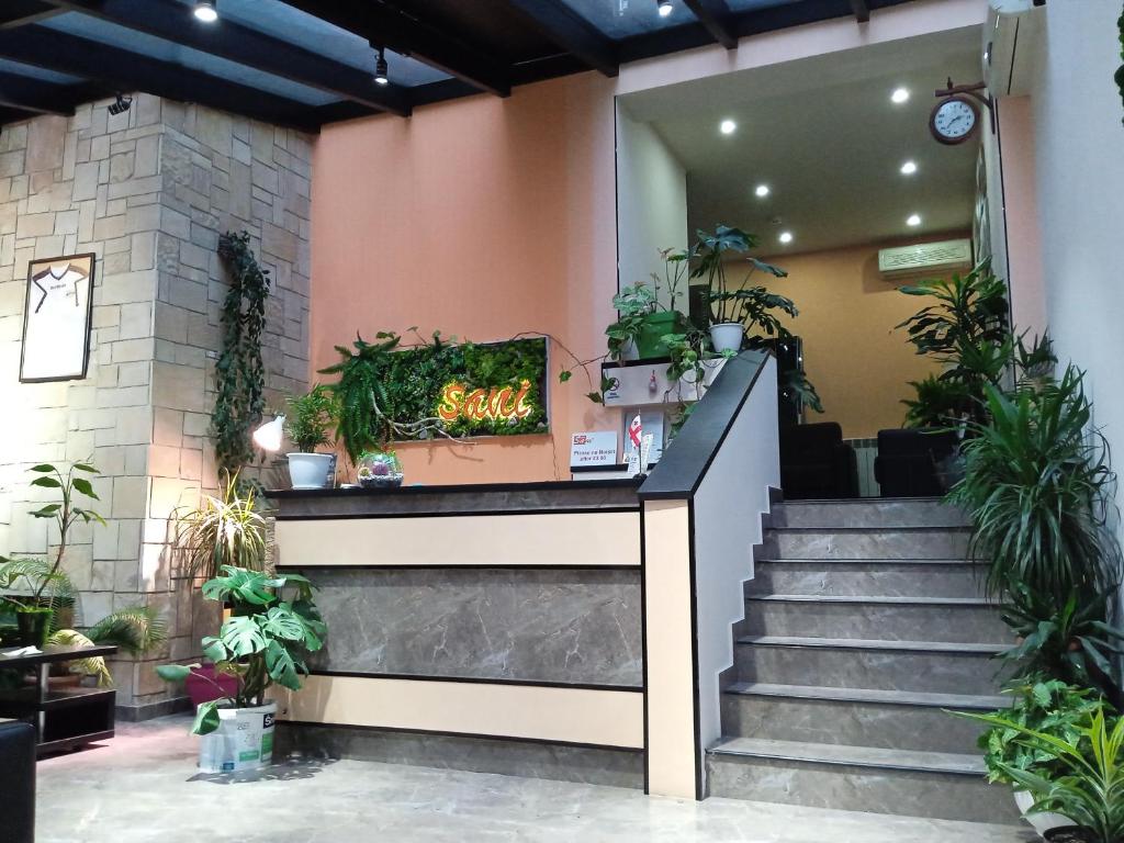 a lobby with stairs and potted plants at Sani Hotel in Tbilisi City