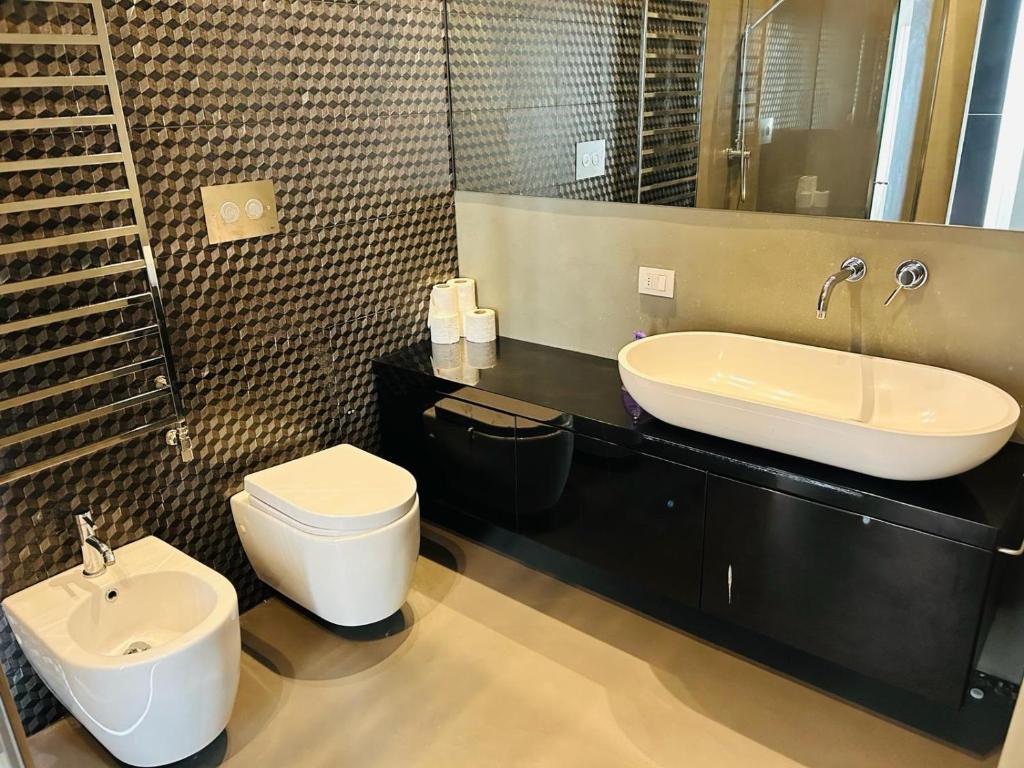 y baño con lavabo, aseo y espejo. en Grand Apartments en Milán
