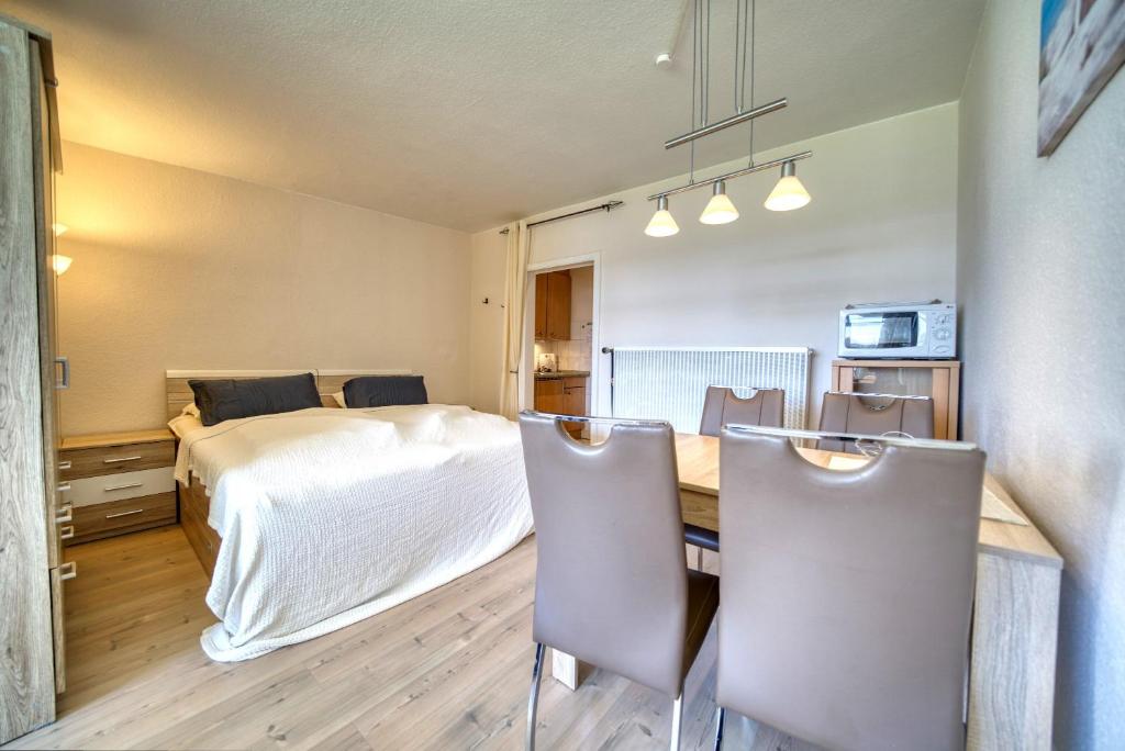 um quarto com uma cama, uma mesa e cadeiras em Strandhotel, App 1SH109 em Heiligenhafen