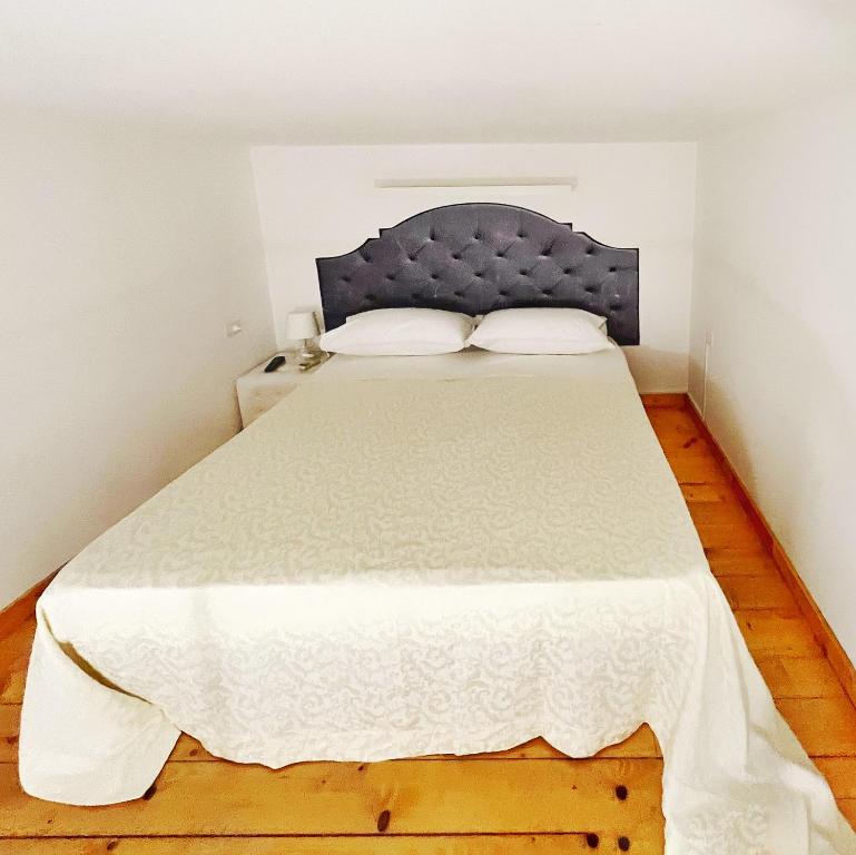 a bedroom with a large bed with a blue headboard at Pantalica Rooms Affittacamere in Sortino