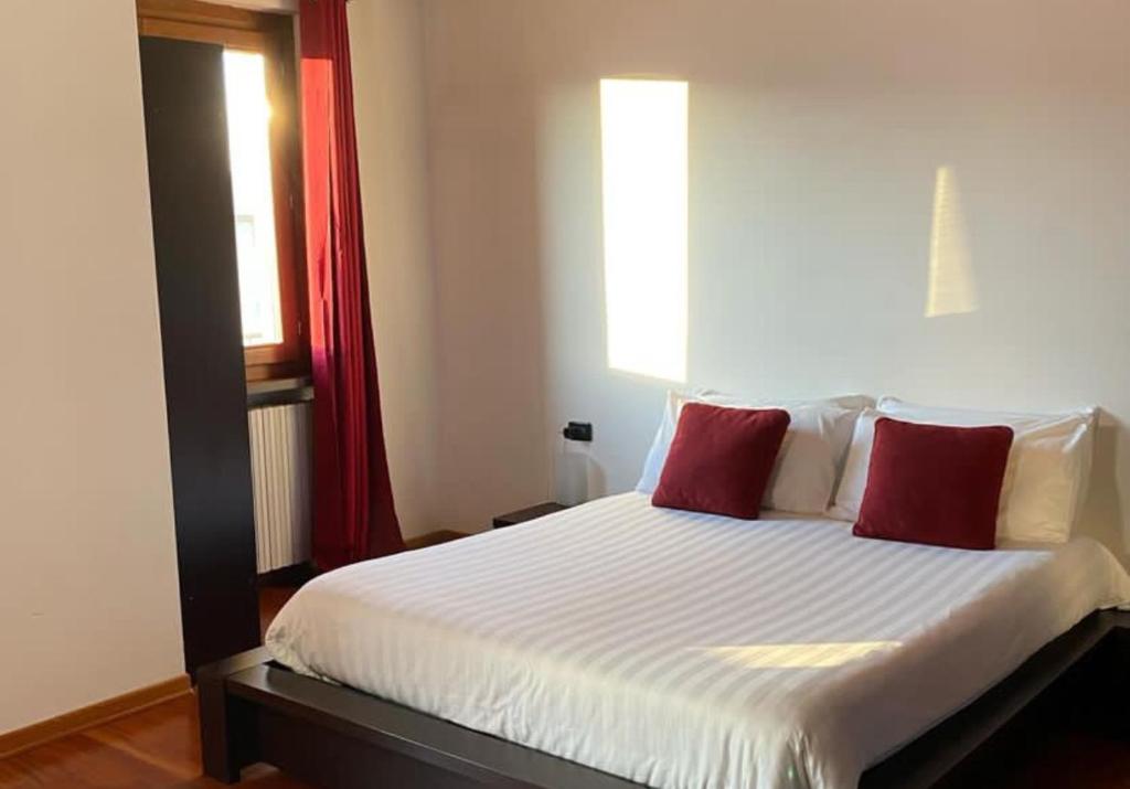 ein Schlafzimmer mit einem Bett mit zwei roten Kissen in der Unterkunft Villa Mattei in Villa Pedergnano