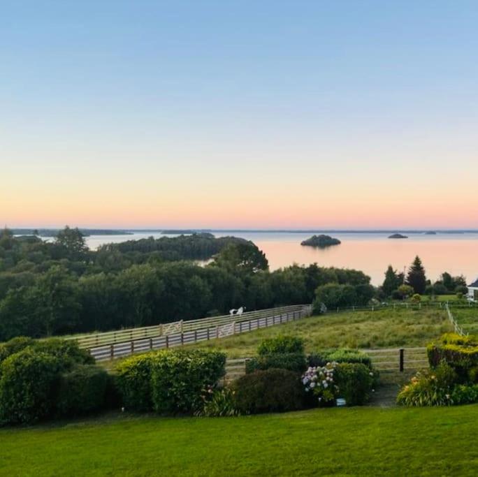 una valla en un campo con vistas al agua en Private apartment ONE on Lough Corrib, Oughterard, en Galway