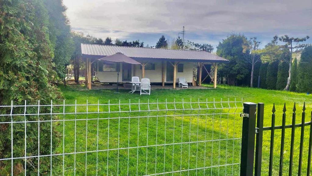a fence in front of a house with a tent at Zacisze nad Sanem 129 a in Załuż