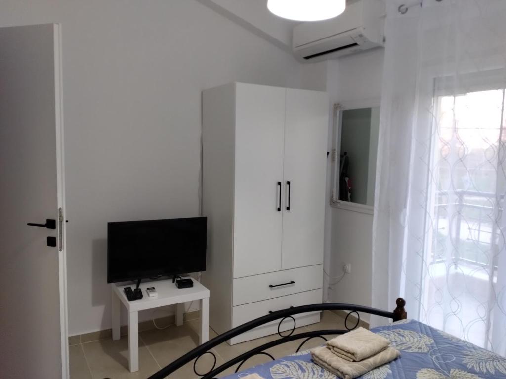 Schlafzimmer mit einem Bett, einem TV und einem Schrank in der Unterkunft Maisonette Fanari in Fanárion