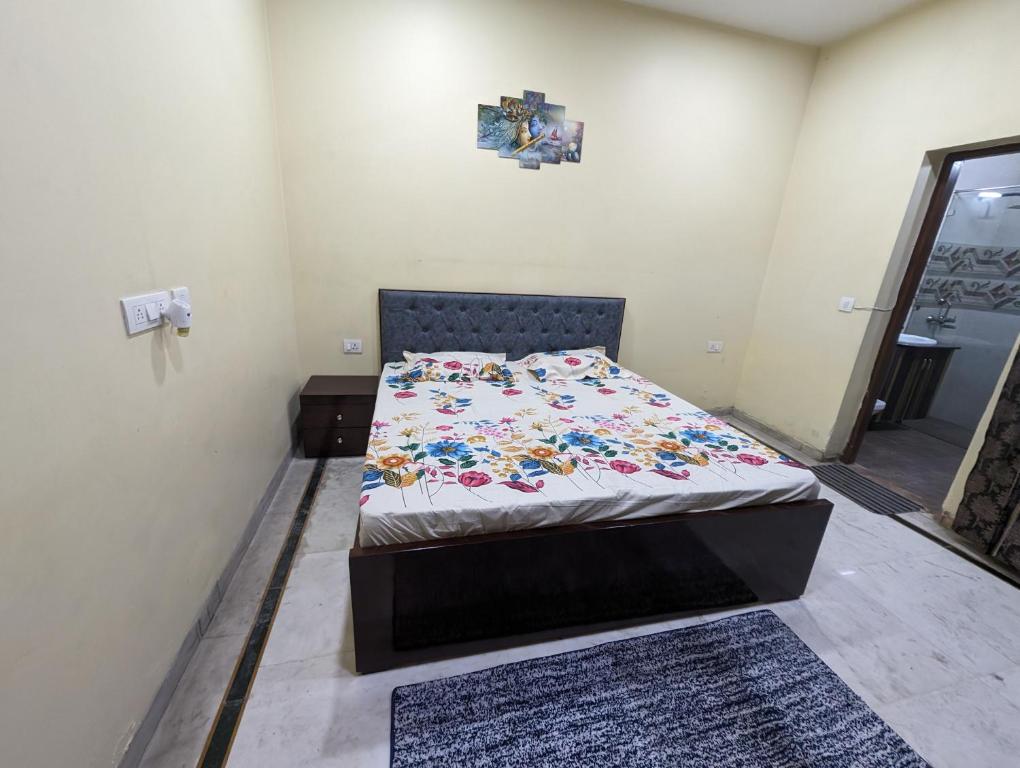 a bedroom with a bed with a floral comforter at Excellent Home Away from Home! in Noida