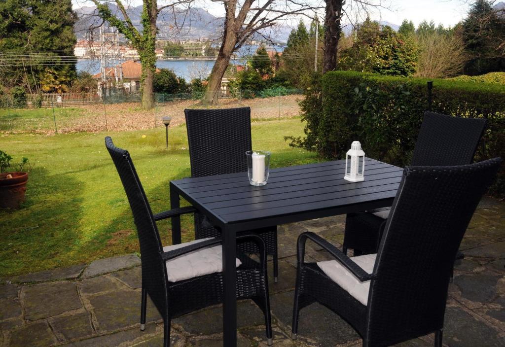 une table noire avec quatre chaises et une table avec dans l'établissement LovingStresa3 giardino del lago, à Stresa