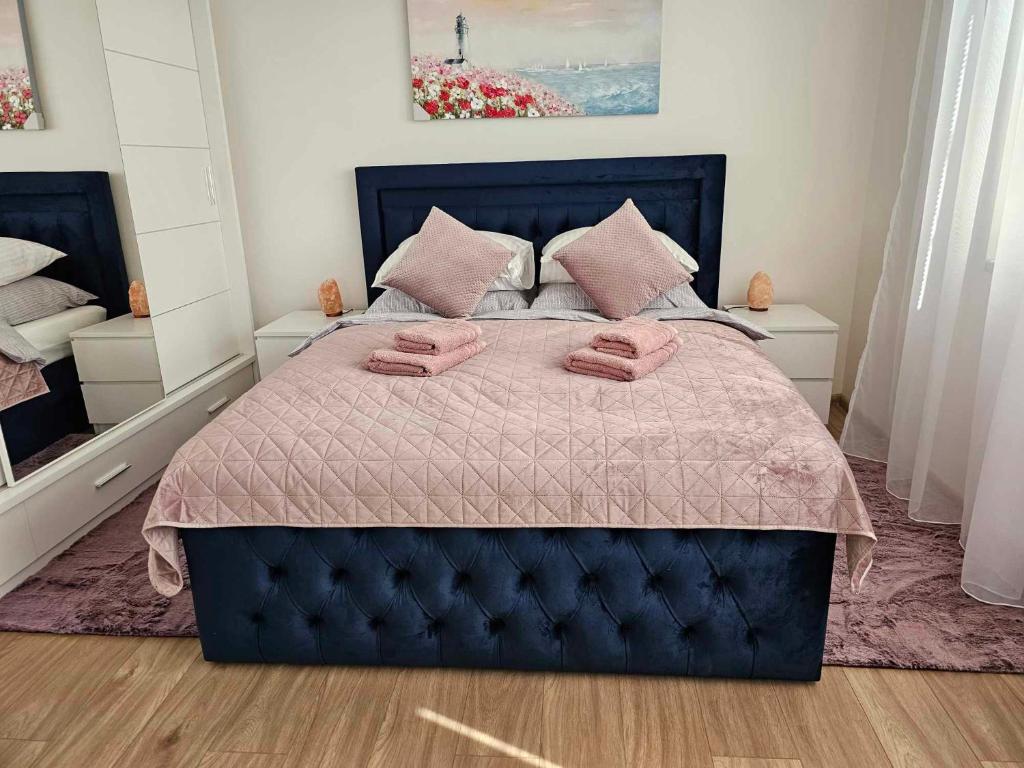 ein Schlafzimmer mit einem blauen Bett mit rosa Kissen darauf in der Unterkunft Velký 2KK, zahrada, parkování zdarma, klidná část Hradce Králové in Hradec Králové