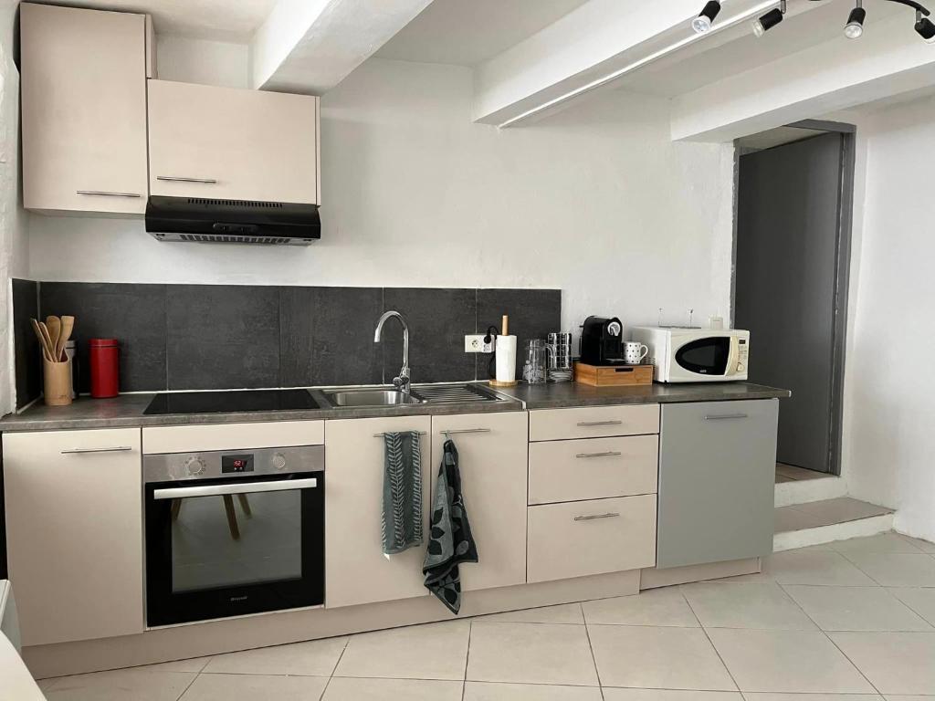 a kitchen with a sink and a stove at Maison de village in Lédenon