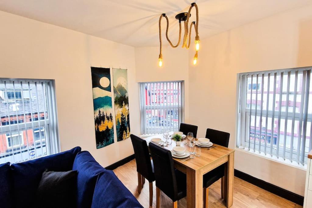 a dining room with a table and a couch at Spacious flat on Breck Road! in Liverpool