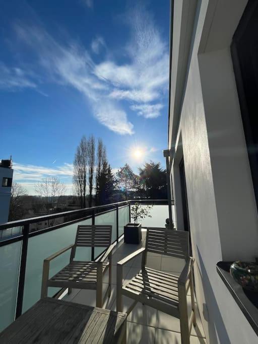twee stoelen op een balkon met uitzicht op het water bij Appartement confort in Garches