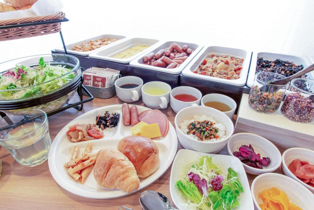una mesa cubierta con platos de comida y tazones de comida en Business Inn Norte, en Sapporo