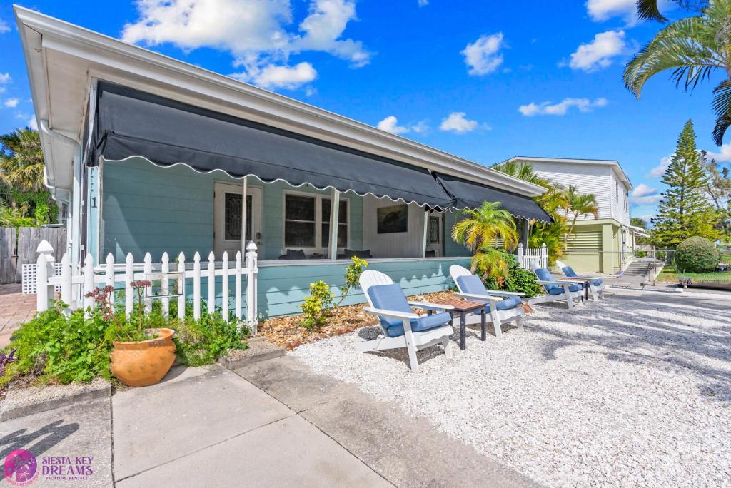 een blauw huis met een wit hek en stoelen bij Siesta Key Village and Beach Walkable, Condo with Private Porch in Siesta Key
