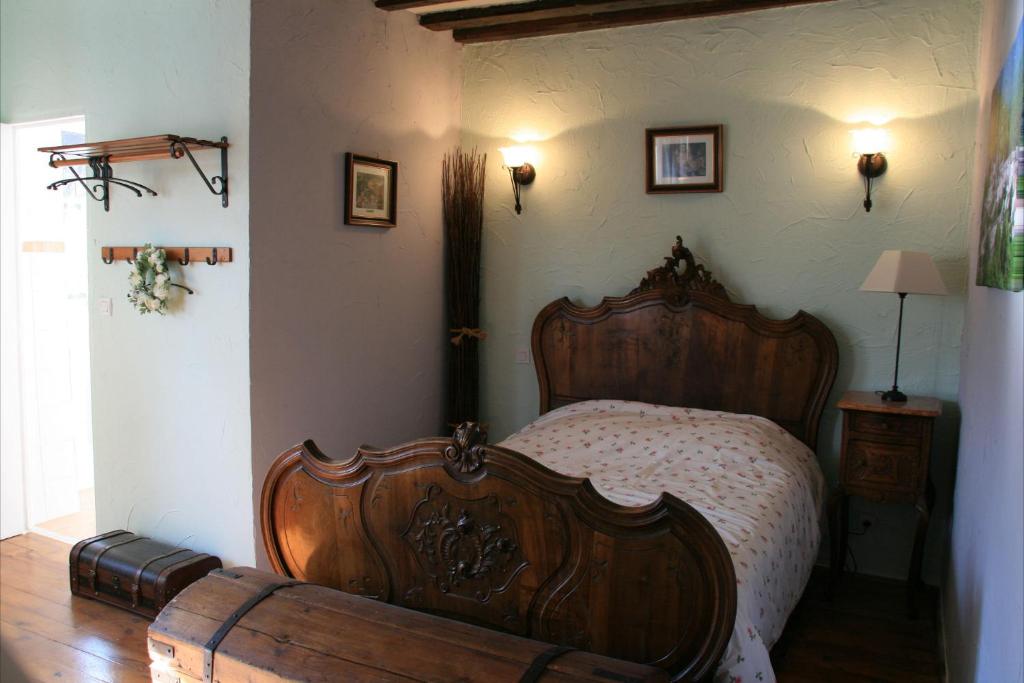 1 dormitorio con cama de madera en una habitación en L'ALMA VIVA (Anciennement La Diligence), en Verdese