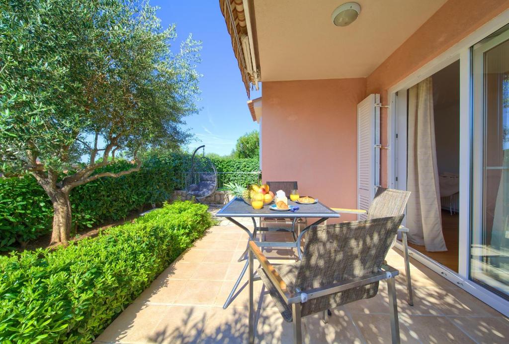 een patio met een tafel en stoelen op een balkon bij Happy Point in Krk