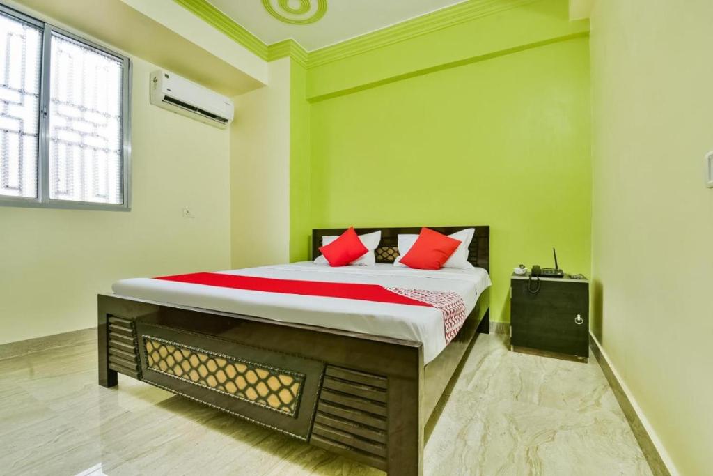 een slaapkamer met een groot bed met rode kussens bij Hotel Mahal Inn in Patna