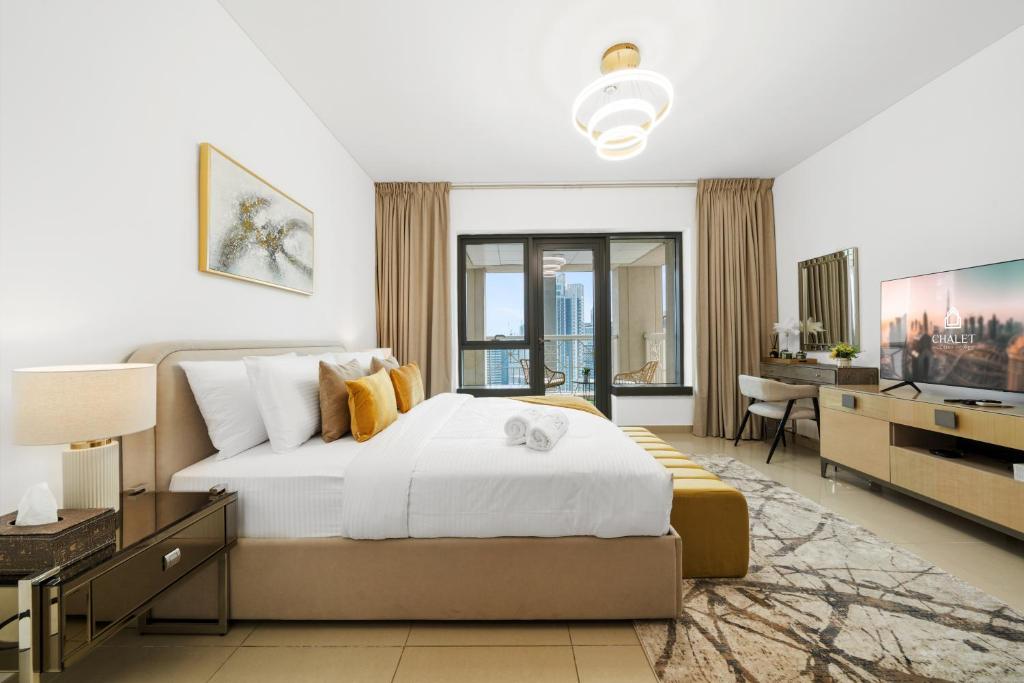 ein Schlafzimmer mit großem Bett und Fernseher in der Unterkunft Luxury Studio, 29 Boulevard near Burj Khalifa Downtown - Chalet Homes in Dubai