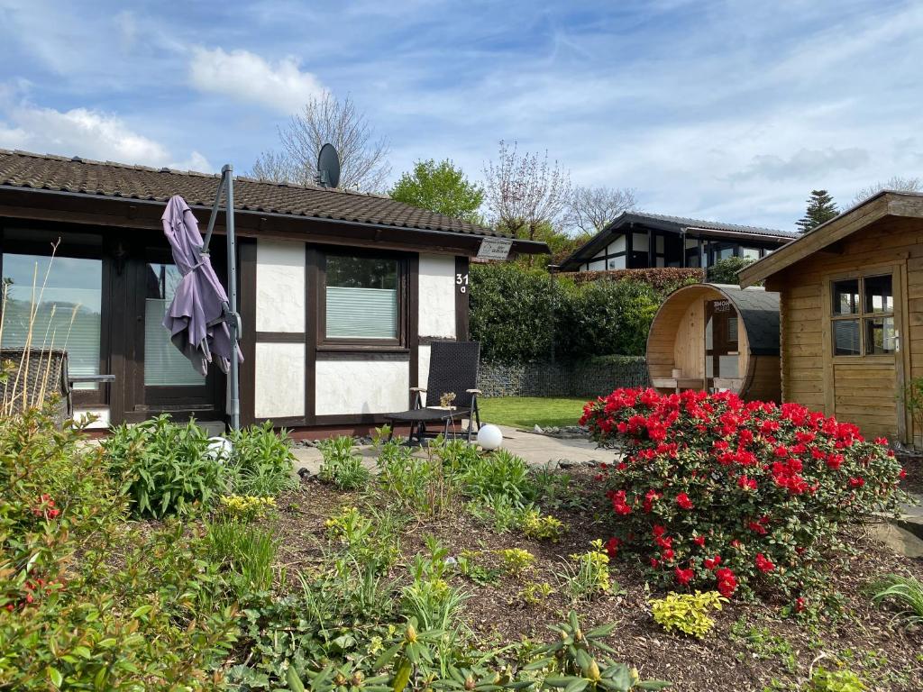 una casa con un jardín con flores en el patio en Henneliebe am Hennesee, en Meschede