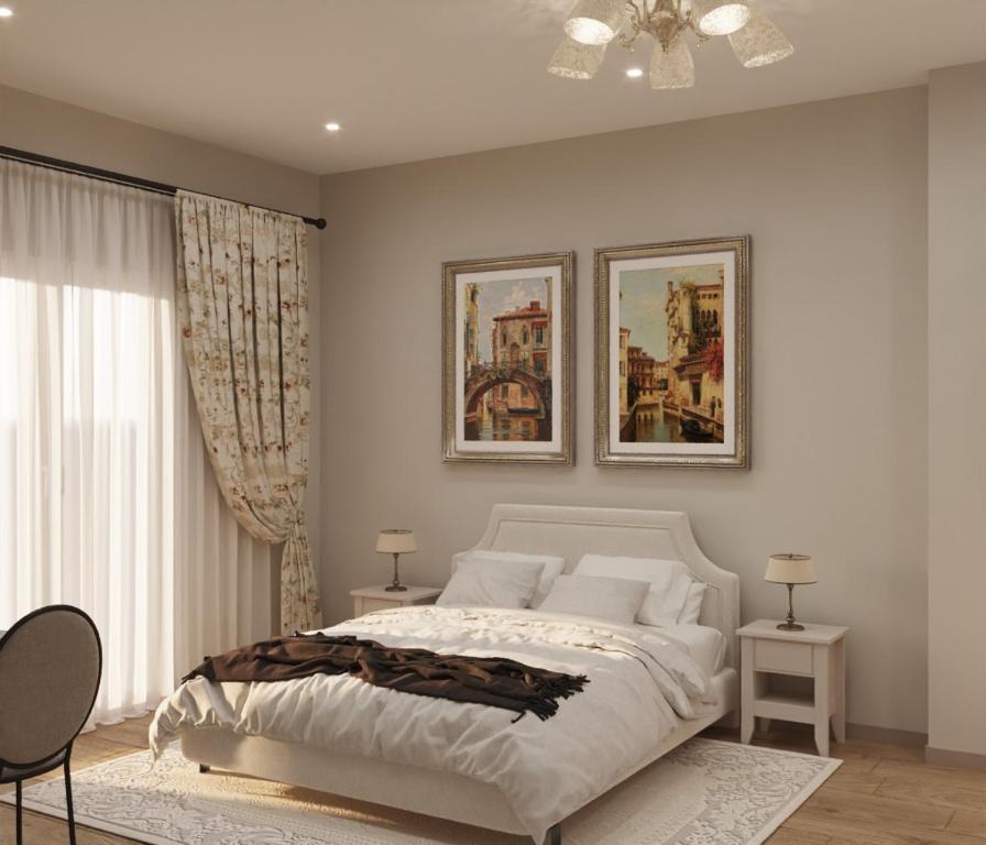 1 dormitorio con 1 cama y 2 cuadros en la pared en Twin Houses Residence, en Tirana