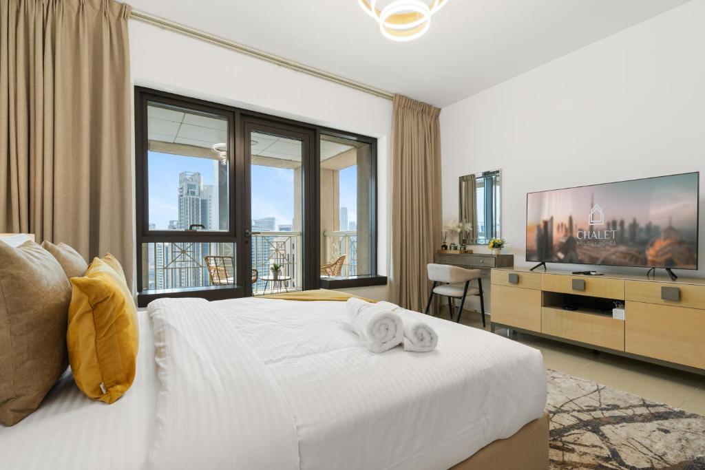 a bedroom with a white bed and a large window at Luxury Studio, 29 Boulevard Burj Khalifa Downtown - Chalet Homes in Dubai
