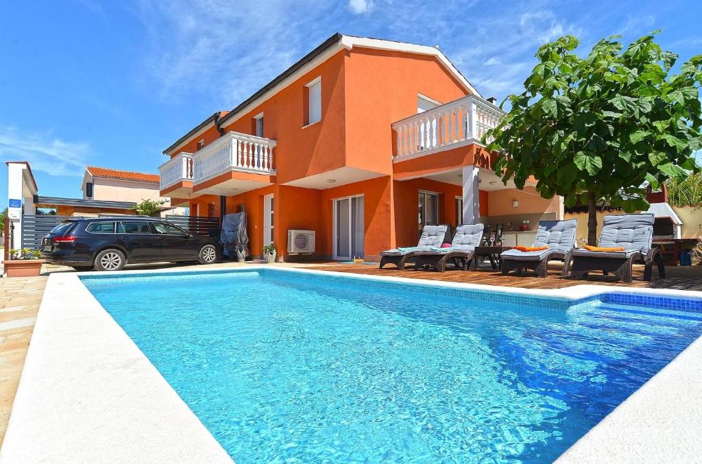 a house with a swimming pool in front of a house at Ferienhaus mit Privatpool für 6 Personen ca 80 qm in Barbariga, Istrien Istrische Riviera in Barbariga
