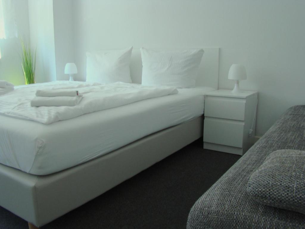 ein großes weißes Bett mit weißer Bettwäsche und Kissen in der Unterkunft Apartments near Kurfürstendamm in Berlin