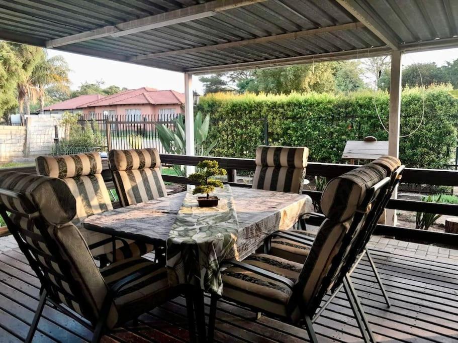 a wooden table and chairs on a deck with a table and chairs at Comfort at its Best! in Brits