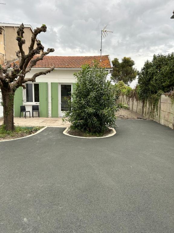 une allée en face d'une maison avec un arbre dans l'établissement Villa bassin d’Arcachon Notre Hutte, à Gujan-Mestras