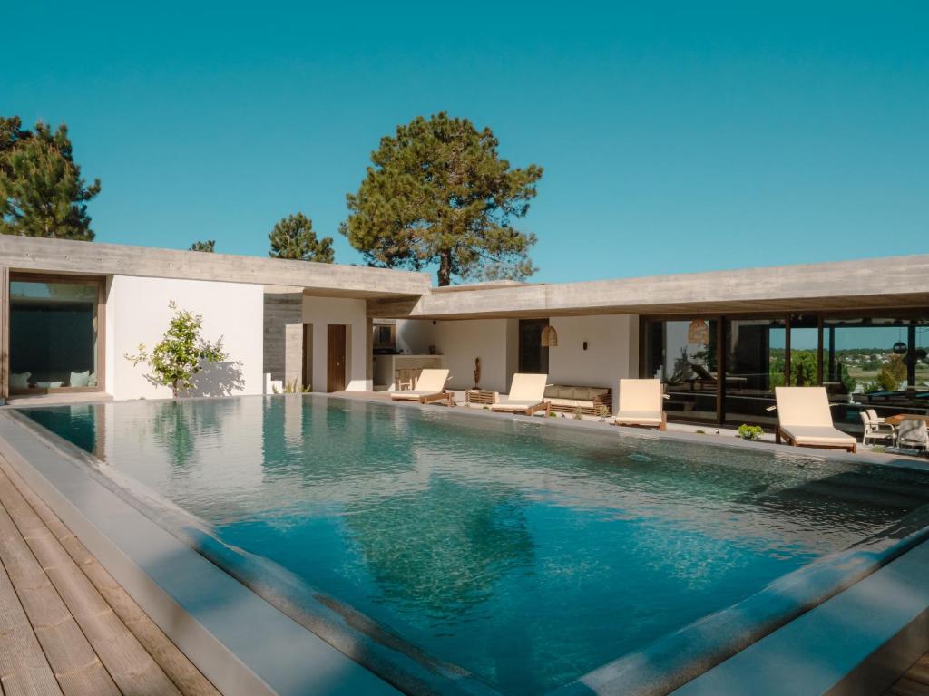 una piscina con sillas y una casa en Villa Amae Deluxe Comporta, en Carvalhal