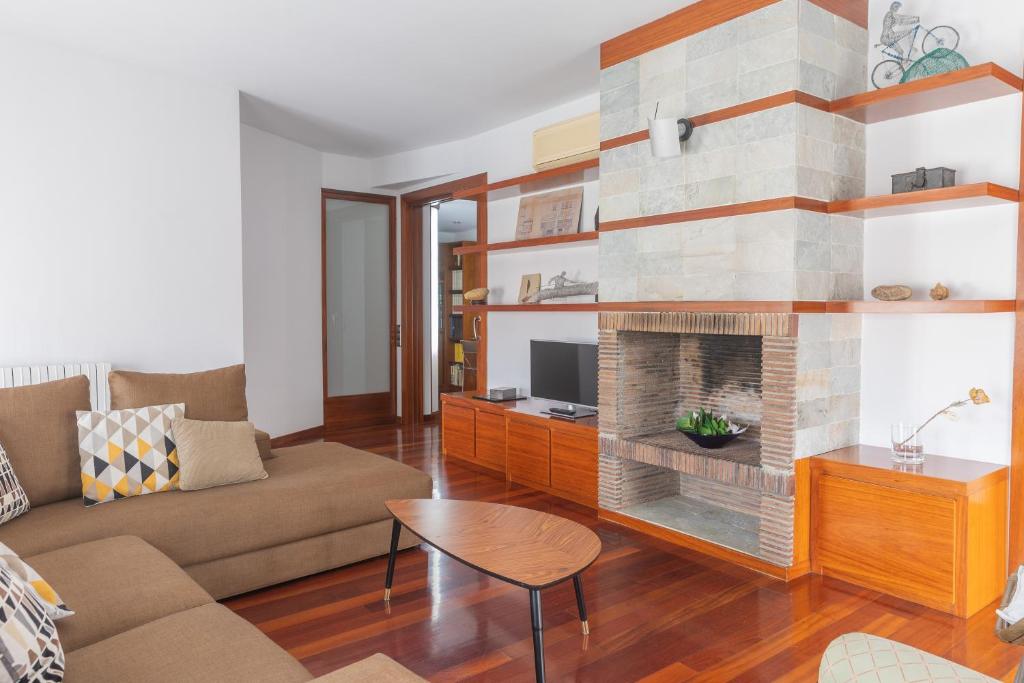 a living room with a couch and a fireplace at Mazi Apartments Colón in Vic