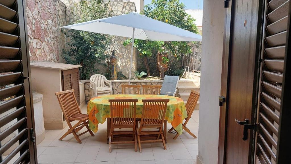 a table and chairs with an umbrella on a patio at Le Case di Giorgia in San Vito lo Capo