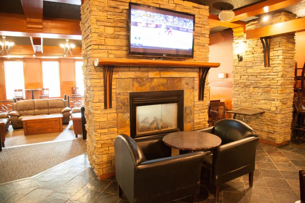 a lobby with a fireplace with a tv on top at Twin Pine Inn & Suites in Hinton
