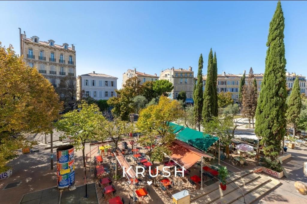 - une vue sur un parc avec des tables et des arbres dans l'établissement Appart plein cœur de Marseille, à Marseille