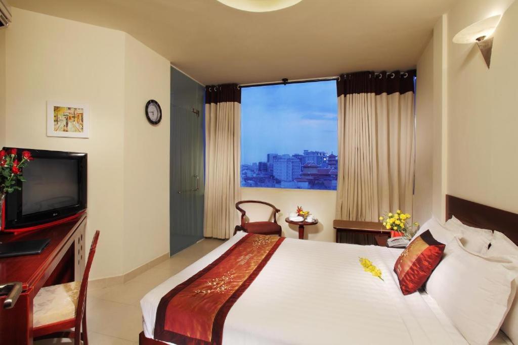a bedroom with a large bed and a television at Kim Yen Hotel in Ho Chi Minh City