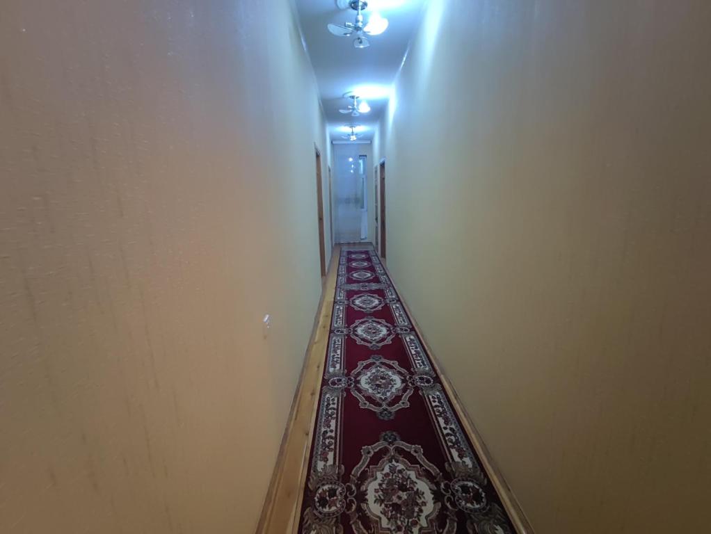 un pasillo con un pasillo largo con alfombra roja en Sheki city villa en Sheki