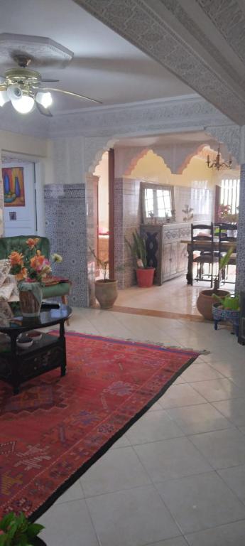 a living room with a red rug on the floor at Dar Ryma in El Jadida