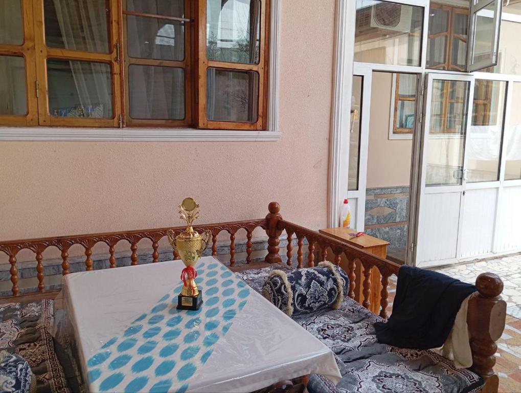 een tafel met een trofee bovenop een balkon bij willa hostel in Yunusobod